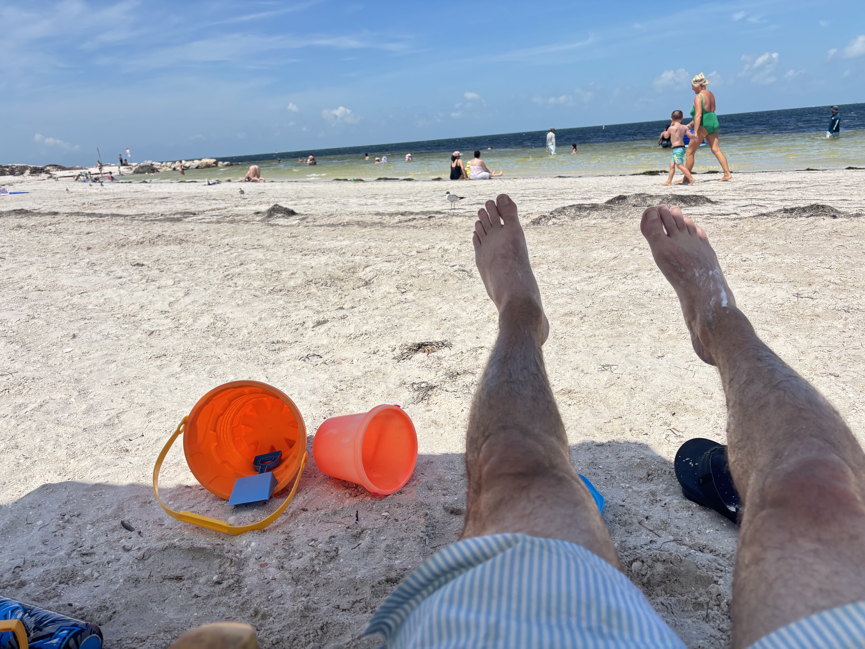 A dad's-eye view of the beach: feet up, sand buckets ready, gulf water ahead